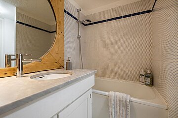 A bathroom with a sink and a bathtub and a mirror