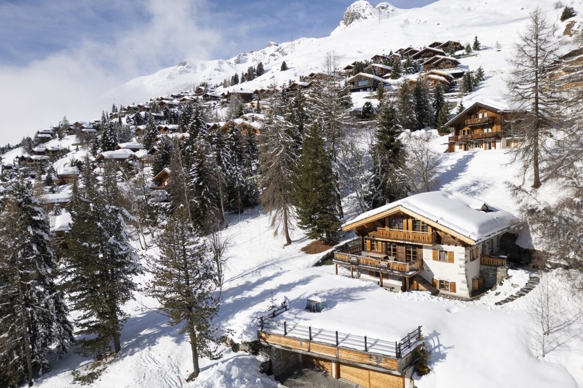 A snowy landscape with a house in the foreground