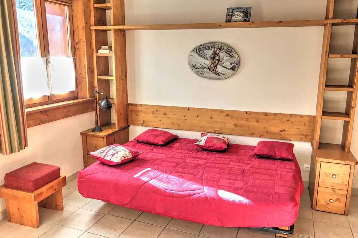 A bedroom with a bed and a clock that says 