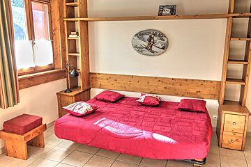 A bedroom with a bed and a clock that says 