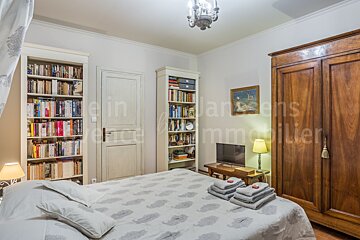 A bedroom with a bed and a bookshelf with the word immobilier on it