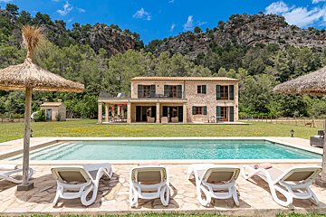A large house with a swimming pool in front of it