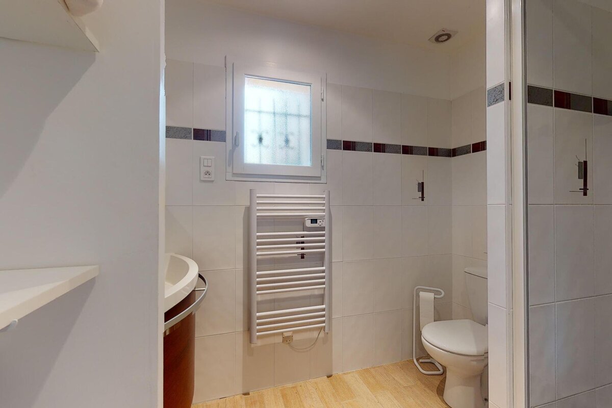 A bathroom with a toilet and a towel rack