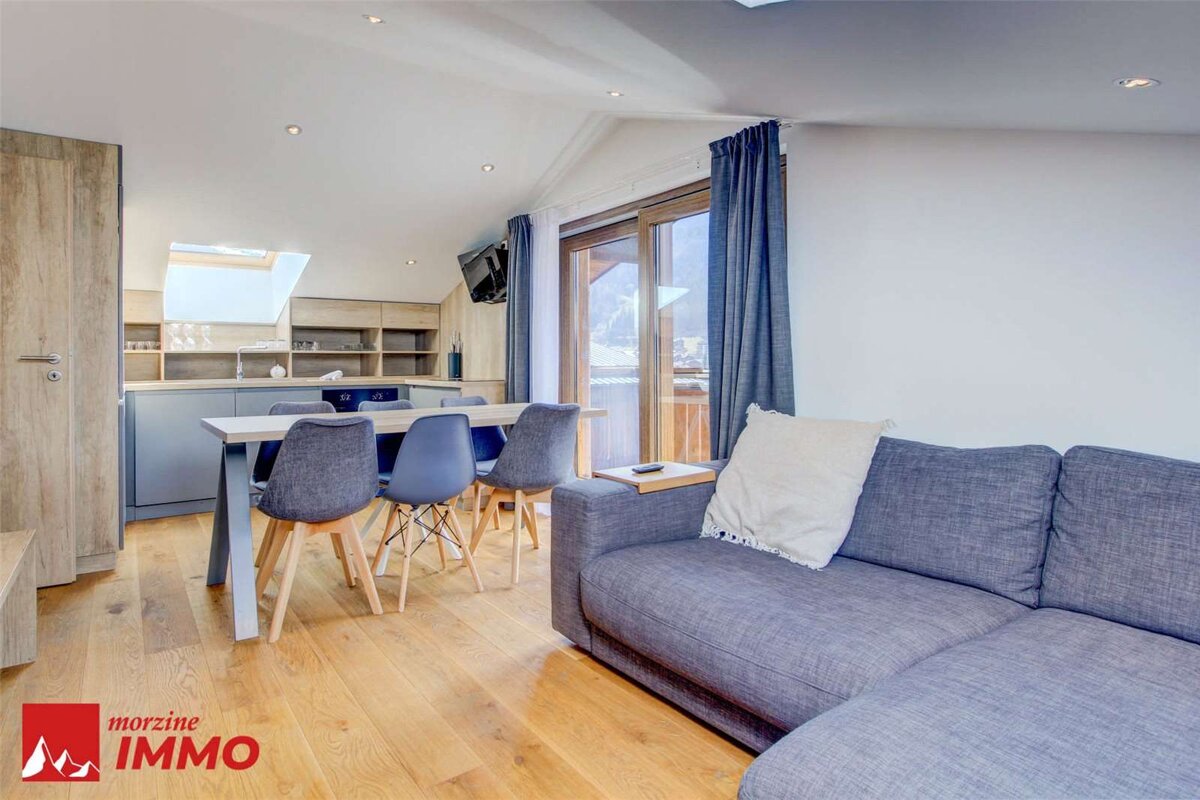 A living room with a couch and a sign that says morzine immo