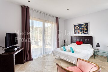 A bedroom with a bed and a television says made in provence