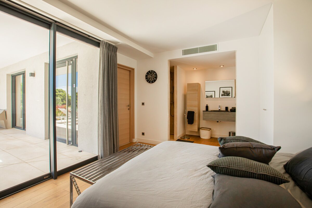 A bedroom with a sliding glass door leading to a bathroom