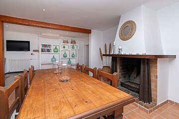 A dining room with a table and chairs and a fireplace