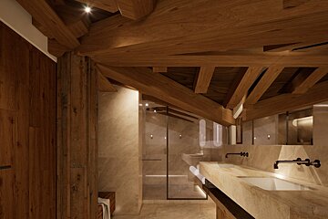 Luxurious modern bathroom featuring exposed wooden beams, marble walls, a double vanity, and a glass shower. The warm lighting highlights the elegant design.