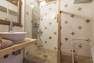 A bathroom with a sink and a walk in shower