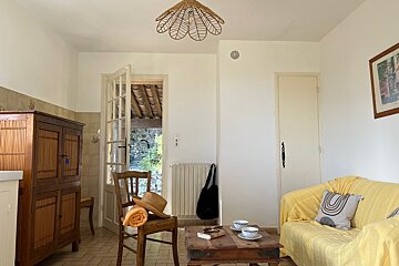 A living room with a yellow couch and a chair