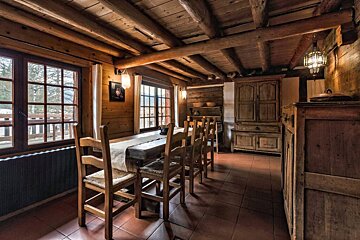 A wooden dining room with a table and chairs