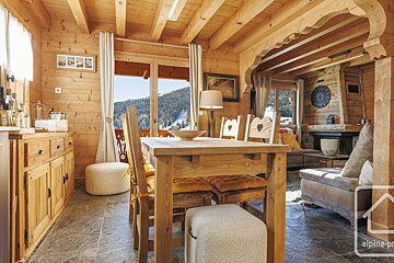 A wooden house with a dining table and chairs