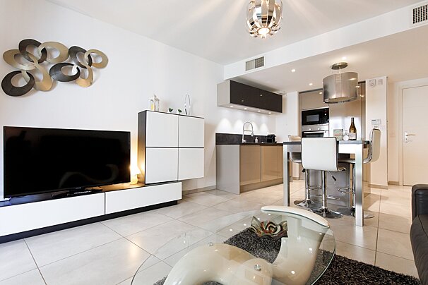A living room with a flat screen tv and a glass coffee table