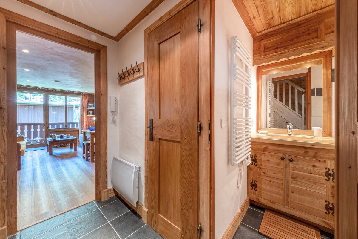 A wooden hallway leading to a bathroom and a living room