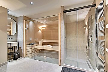 A bathroom with a sliding glass door leading to a sauna