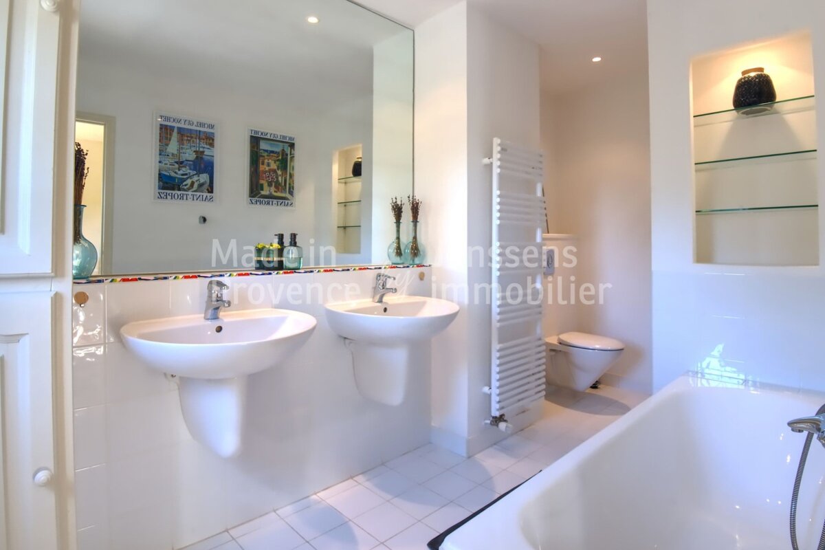A bathroom with two sinks and a bathtub and a sign that says provence immobilier