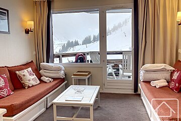 A living room with a view of a snowy mountain
