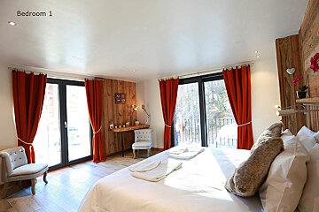A bedroom with red curtains and a large bed
