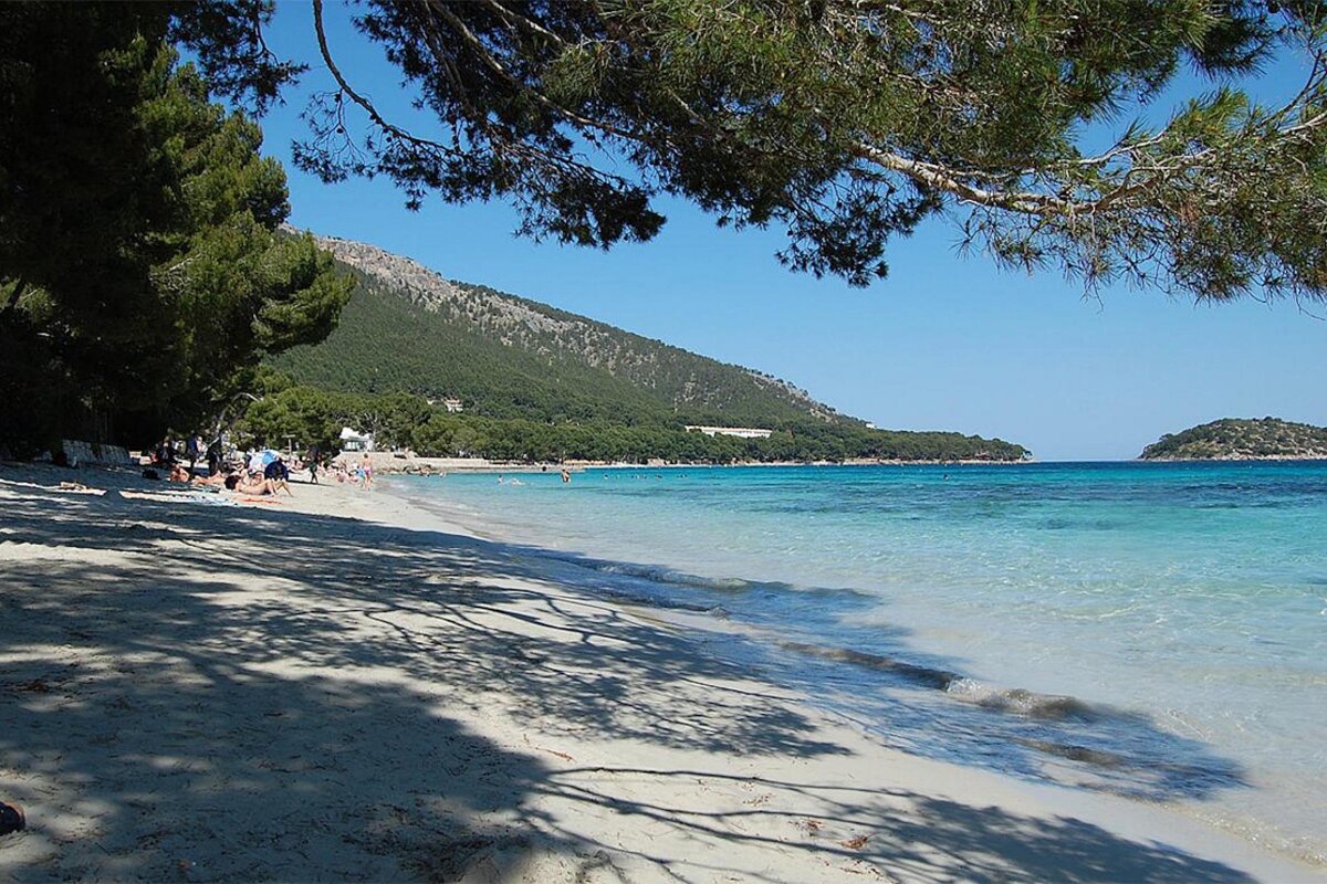 A sandy beach with a mountain in the background