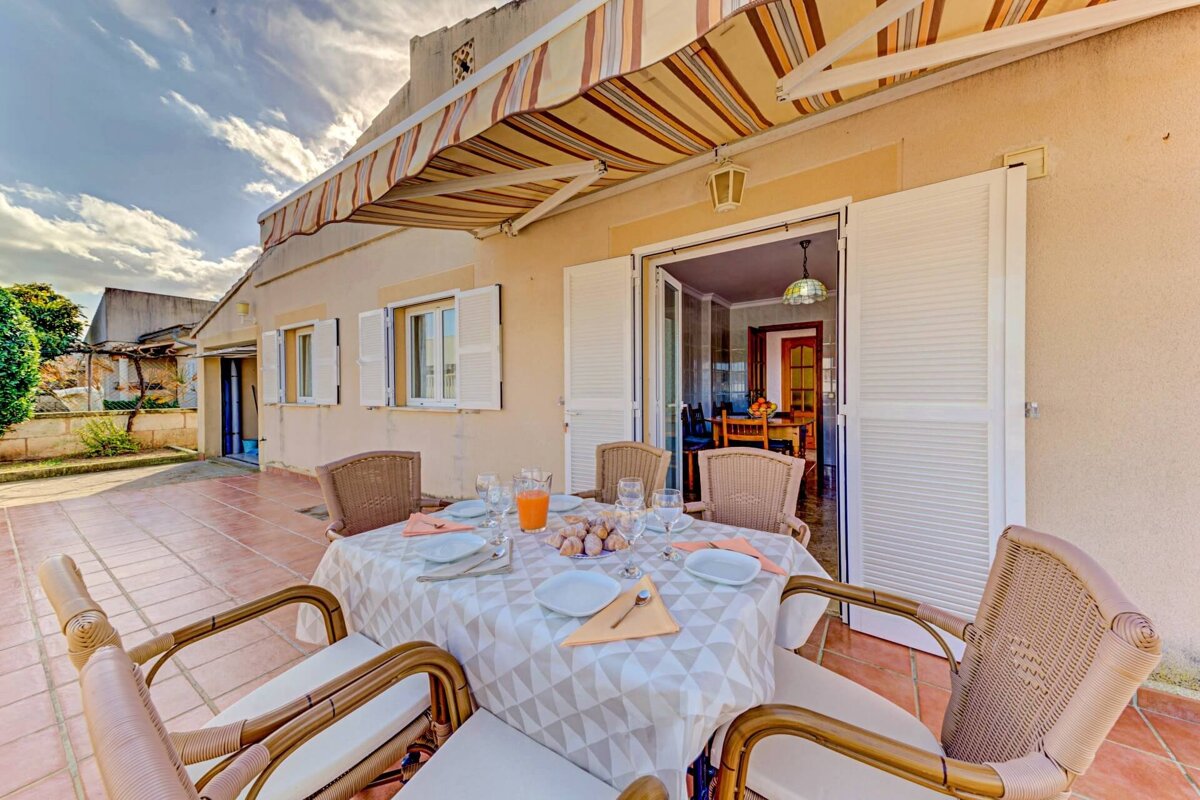 A patio with a table and chairs under an awning