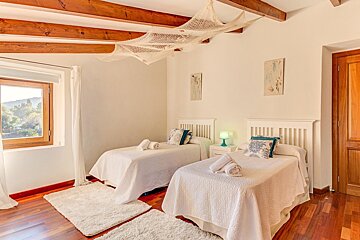A bedroom with two twin beds and a window
