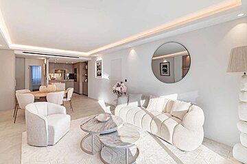 Chic, minimalist open-plan living area featuring a neutral palette, elegant curved sofa, marble tables, and a dining space with light wood accents.
