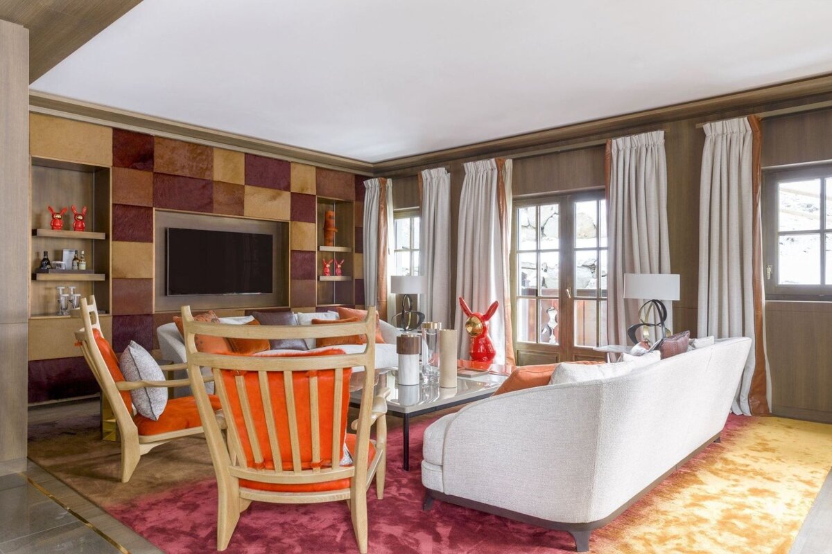 A living room with a couch and chairs and a flat screen tv