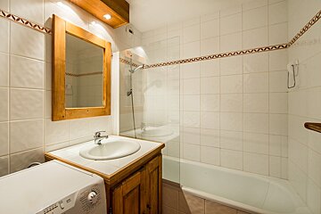 A bathroom with a washing machine and a sink