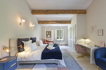A bedroom with a large bed and a desk