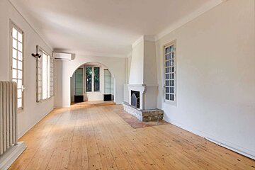 An empty living room with hardwood floors and a fireplace