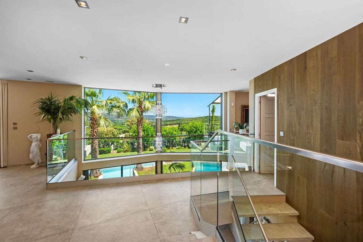 A staircase with a glass railing leading up to the second floor