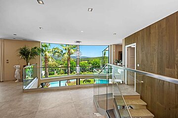 A staircase with a glass railing leading up to the second floor