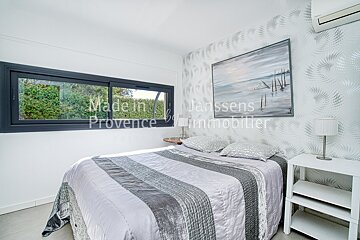 A bedroom with a bed and a painting that says made in janssens provence