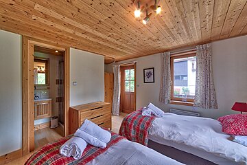 A bedroom with two beds and a dresser