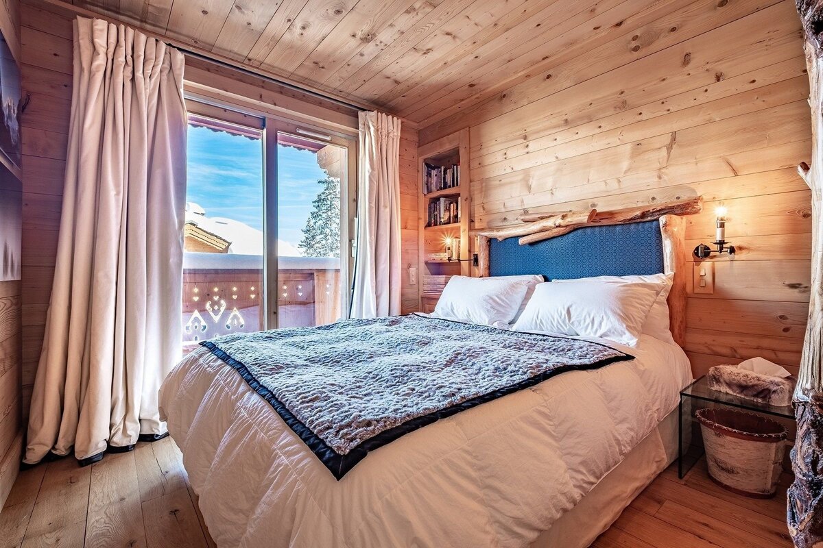 A bedroom with a bed with a blue headboard