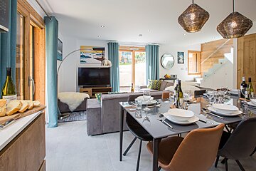 A living room with a dining table and chairs and a tv
