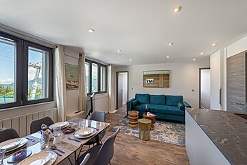 A living room with a blue couch and a dining table