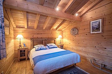 A bedroom with a bed and a picture on the wall