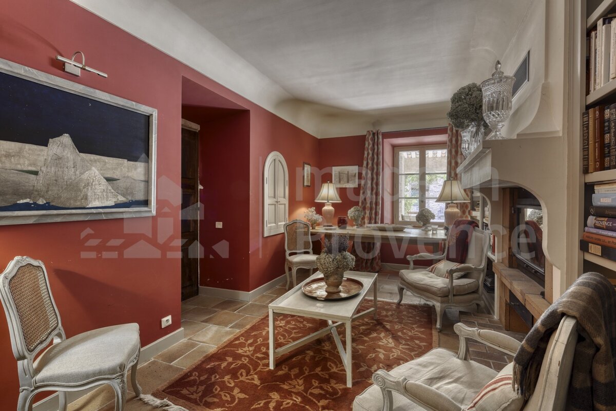 A living room with red walls and a bookshelf with a book titled provence
