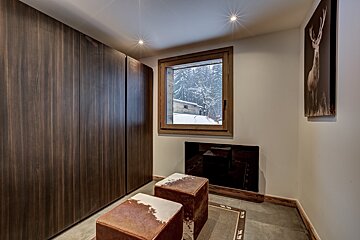 A room with a window and a picture of a deer on the wall