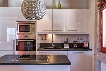 A kitchen with white cabinets and a bosch oven