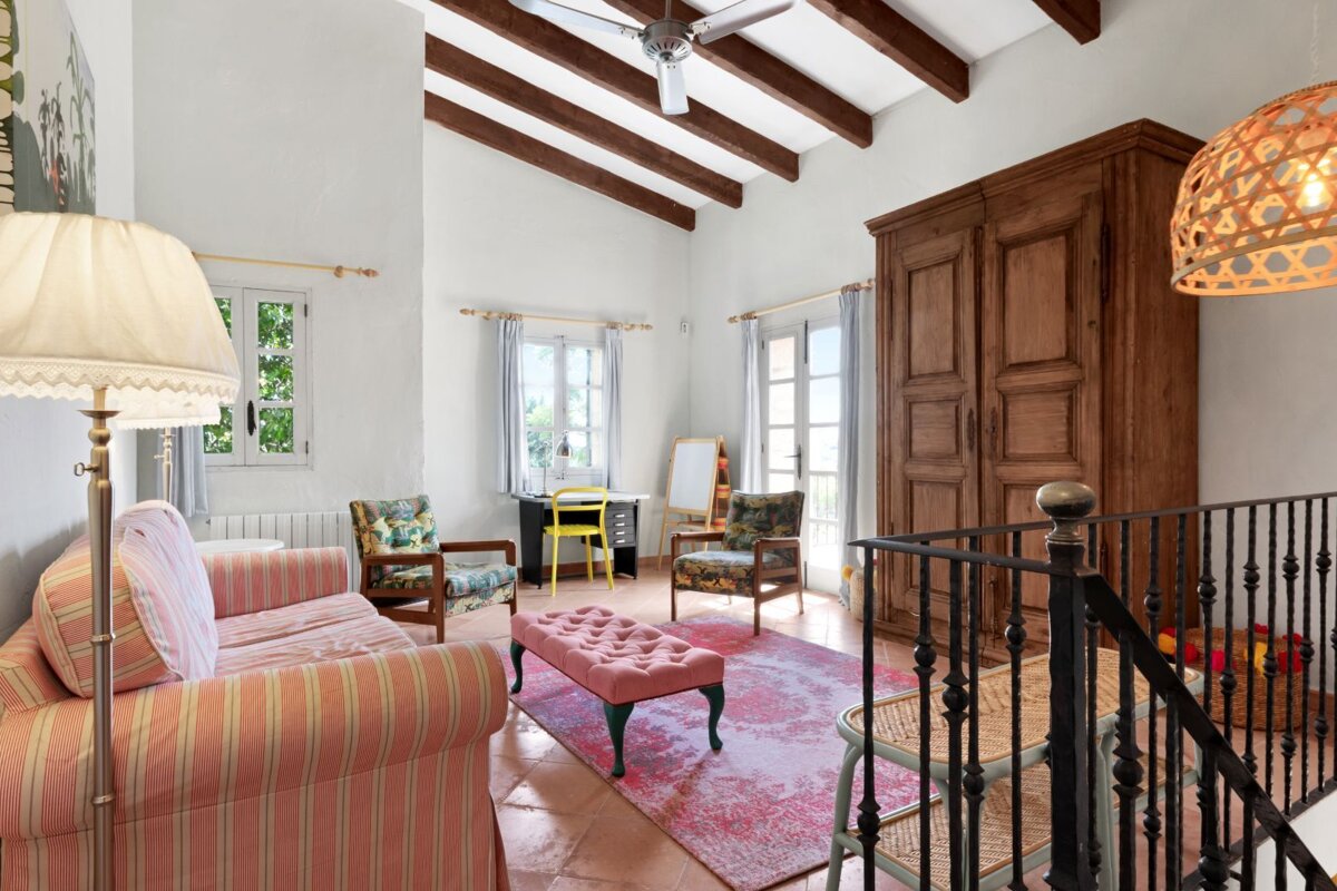 A living room with a striped couch and a pink rug