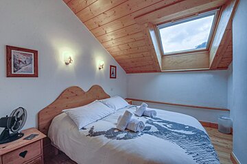 A bedroom with a bed and a picture of a skier on the wall