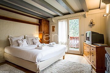 A bedroom with a king size bed and a flat screen tv