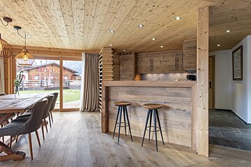 A dining room with a wooden table and chairs