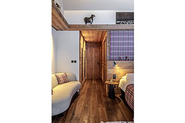 A bedroom with a couch and a purple plaid wall