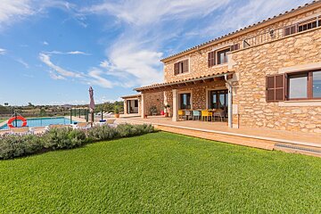 A large stone house with a large lawn in front of it