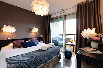 A bedroom with a large bed and a sliding glass door