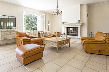 A living room with brown leather furniture and a fireplace