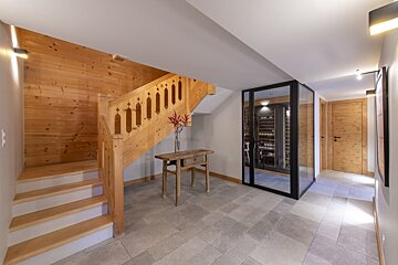 A wooden staircase in a hallway with a glass door